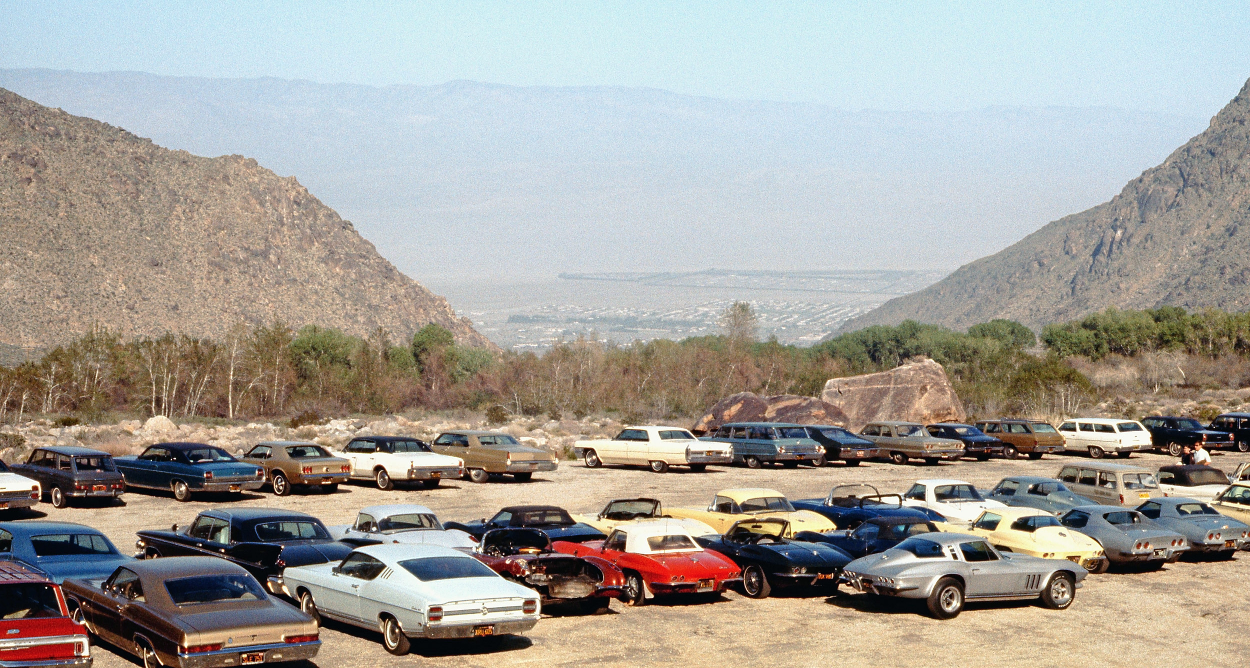 A shot of serendipity at the parking lot, base of the Palm Springs Aerial Tram, March 1969.  Has the view of the desert below changed much today? Love the spunk of the guy with the older Corvette, half of the rear fiberglass clip missing. View full size.