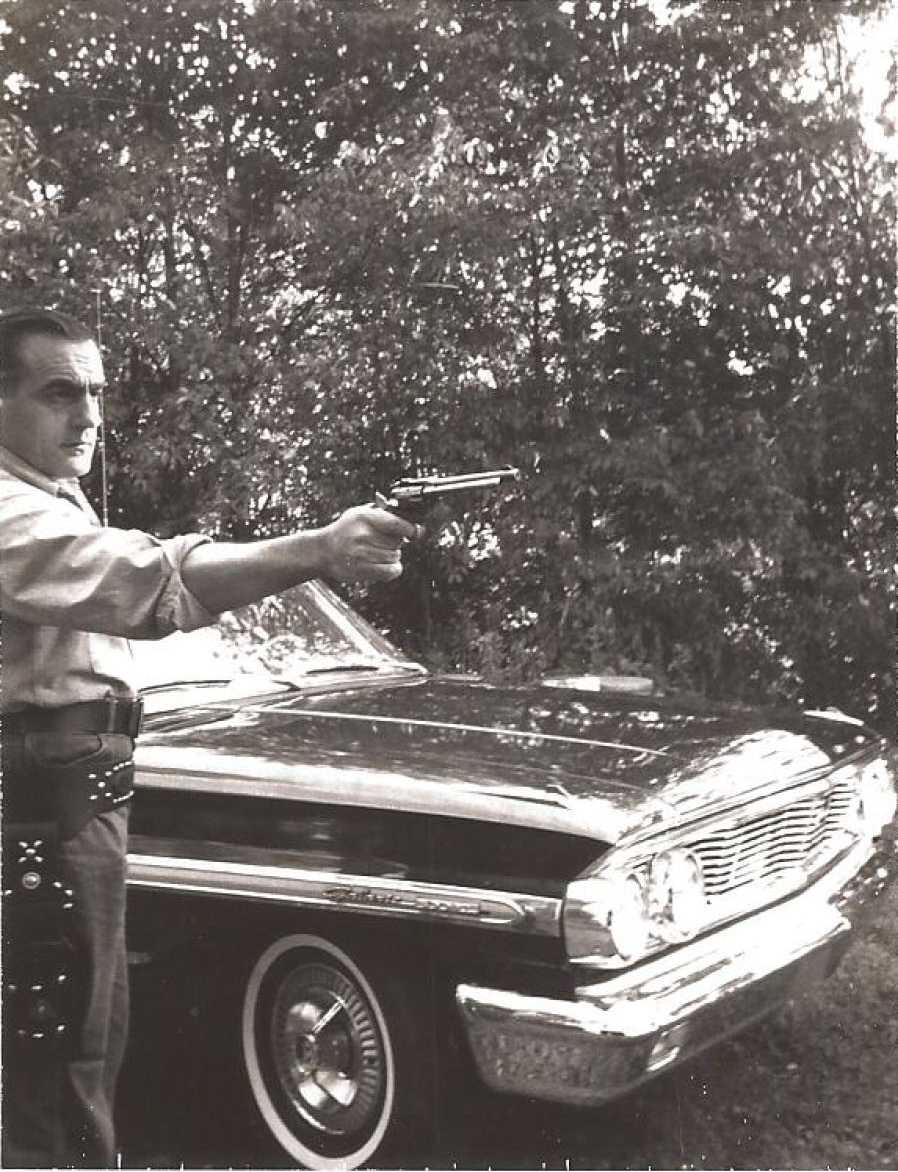 My dad Tony showing off his new 1964 Ford Galaxie XL 500 and making sure no one goes near it. He is holding a Ruger Blackhawk .22 and is wearing a custom made holster. Picture was taken by my mother at my childhood home backyard in New Castle, PA.  Dad traded in the car in 1969 where the new owner gave it an early demise 3 months later.  View full size.