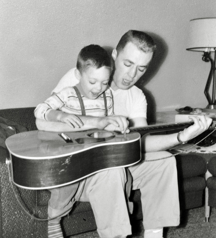 This is a great picture.  My brother turned out to be an awesome guitar player; he repairs them too. The photo must have been shot around 1959 or so. My dad kept that guitar since his teen years and now my brother owns it.  It's an old Gibson LG something or other; pretty beat, but it sounds great. View full size.