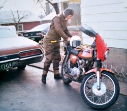 It must have been cold, he's all bundled up.   I think that bike was a 71 Honda CL175 Scrambler.  Around 1973 or 74 in Akron, Ohio. View full size.
I Can RelateI empathize with your Dad in this photo. It brings back some memories.
In 2nd year university, early 70s, I drove home in late March for a long weekend (Easter?) on my 1970 Kawasaki 350 Avenger (two-stroke), a trip of about 250 miles on freeway. Problem was, it was Canada, and it was just above freezing. I recall grimly stopping midway at a service center off the highway and shaking for minutes over my restaurant coffee before heading out to finish the trip.
That Kawasaki was scary-fast, as a quick twist of the throttle in 2nd or 3rd gear would lift the front wheel. It was way too light, powerful and squirrely for young guys like me. But I guess they were nothing compared to what's out there today...
(ShorpyBlog, Member Gallery)