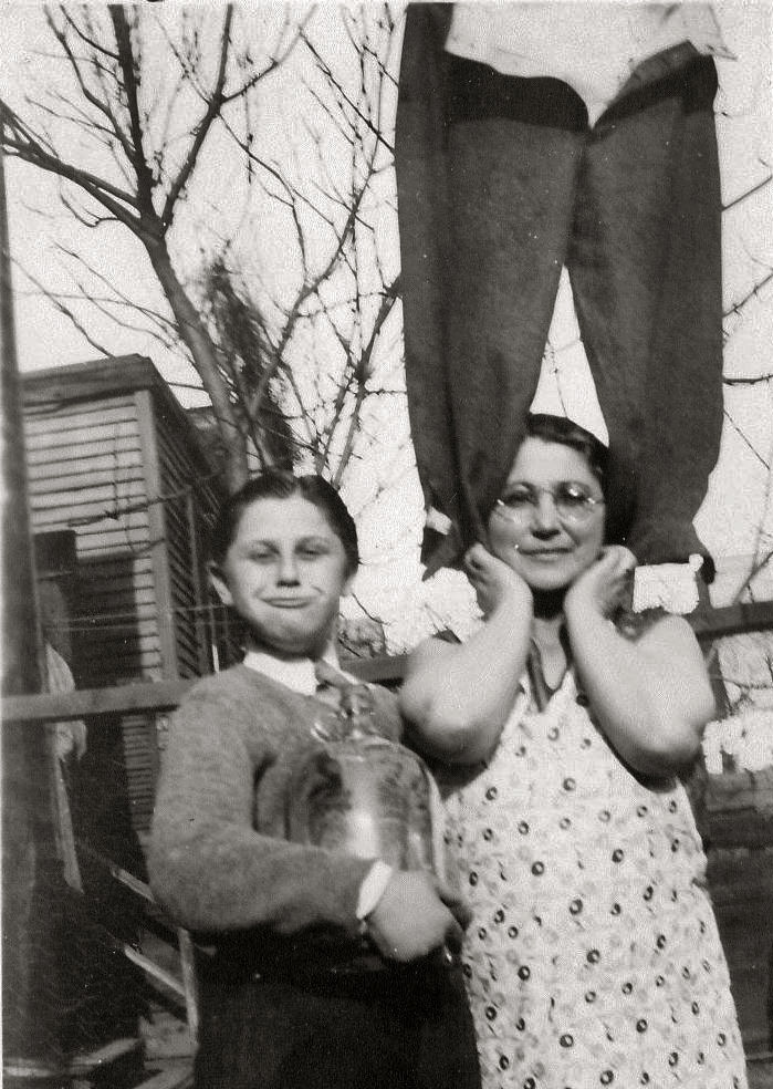 Photo from 1927. This is my father, David Berger, at the age of 10. He came from a Brooklyn, N.Y., from a family that had a weakness for jokes and humor of every type imaginable. All of his siblings, with one exception, were natural comedians, offering the world laughs and smiles every chance they got.  The fact that his mother, my Granny Rose, agreed to be a part of this "unusual photo," combined with the mischievous look on Dad's face attests to that. (The owner of the legs standing atop Rose's shoulders is lost in anonymity). I have no idea exactly what Dad is holding, but I'm thinking it's an equally young Stanley Cup.

My very special and unique father died in 1973 at the age of 55. View full size.
