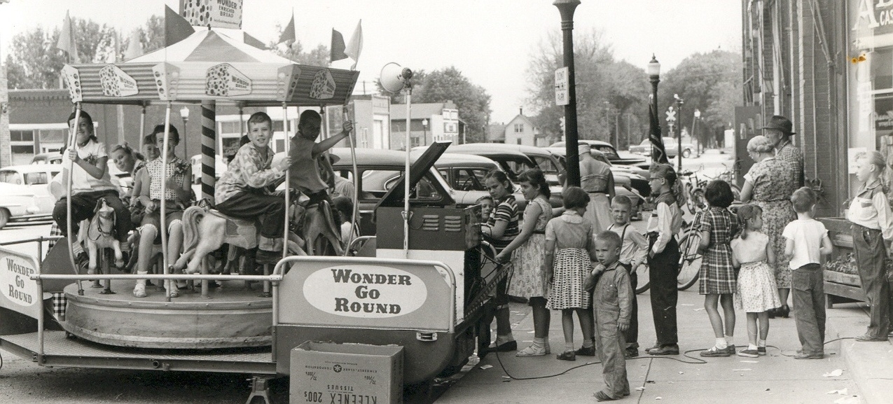 The Wonder-Go-Round made its visit to Dexter, Iowa, thanks to Adkin's Cash Foods and the Wonder Bread people in this 1950s view.  It looks like every kid in town turned out to take a spin!  View full size