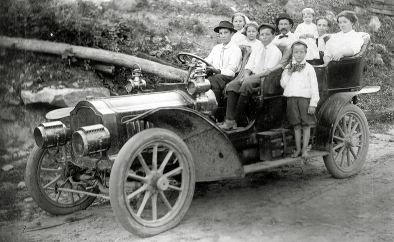 The Walter Figot Dudley family, taken in Raleigh County, West Virginia in 1911. I believe the car is a 1911 Packard “Thirty” Touring Car which sold for about $4000 at the time. Walter, with the mustache, is in the rear seat; the baby is my uncle, Frank Edward Dudley, being held by Walter's wife, Florence. Daughter Margaret is seated next to Florence.  The driver is James Dudley seated next to brother Roy. Seated behind James are sisters Thelma and Grace. Brother Ray is on the running board. Walter and his wife operated a boarding house for coal miners while in Glen White, WVA. He died during the great Influenza pandemic in 1918 and is buried in Ironton, Ohio. View full size.
