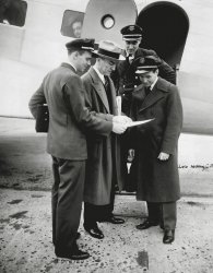 Here he is again, my Gramps, Warren Erickson, at the top of the steps. This time he is in Chicago in 1934 with Captain Eddie Rickenbacker, who's wearing the fedora. This is possibly a DC-1 or DC 2, since the DC-3 entered service a couple of years later. I'm sure this shot of them all looking with interest at some paper was posed; the passenger looking out the window may be thinking "OK, let's get this show on the road." View full size.
(ShorpyBlog, Member Gallery)