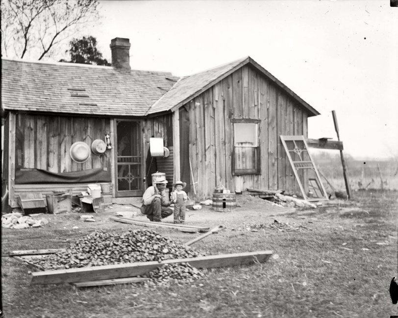 A father and son outside of their rural Charles City, Iowa home, circa 1908. Found in a collection of glass negatives.