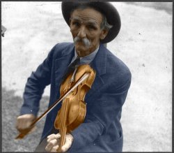 Colorized version of Ben Shahn's photograph of Bill Hensley, a mountain fiddler from Asheville, North Carolina.  Like many of our local "hillbilly" music makers, Bill Hensley was probably self-taught, could not read music but could play tunes that were handed down through families and friends for years. The strong Scots-Irish influence in local music is still evident today. View full size.