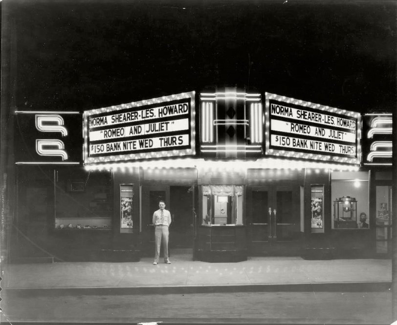 The Gem Theater located on North Main Street in downtown Charles City, Iowa, circa 1936. Theater manager Jack Kuech is pictured under the marquis of the 1936 version of Romeo &amp; Juliet being promoted.  Popcorn sales look to be a little slow.  Acetate negative. View full size.
