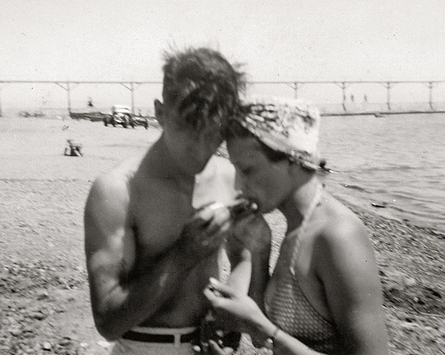 My fav candid shot of Grandma & Grandpa Hughes, taken at Silver Lake, Wisconsin, 1942.  Not quite sure what they're doing (is he feeding her something or lighting her cigarette maybe?).  They're not around anymore to say & daddy doesn't remember either (he was only 5 when this was taken).  Any guesses out there?  Thanx! 