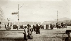 Photo taken at, what looks to be, the intersection of Pont Du Mont Blanc and Quai Du Mont Blanc.  Written in pencil on the back is the following:

One of Geneva's busiest corners - Carriage to the right is on bridge crossing Rhone. To the left port of Geneva with "Les Voirons" in back ground. Mountain in the center is the Môle.