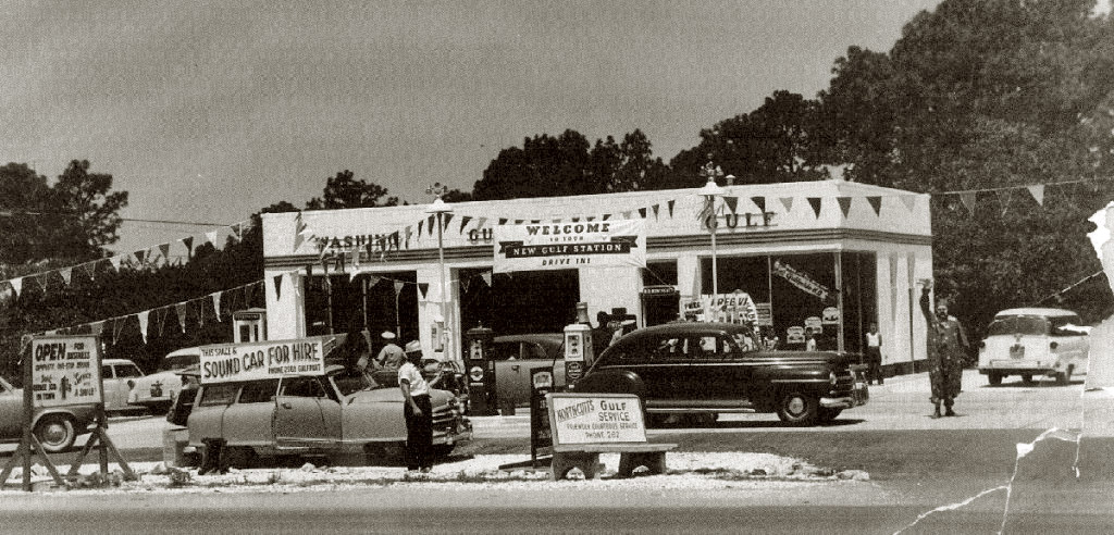 Grand opening of my father's Gulf Gas station in Gulfport, Ms, circa 1955. The family's 2-door Ford station wagon to the right of the building would make two cross-country Mississippi to California trips in a few years before we finally settled in The Promised Land of southern California. The clown's outfit was covered with Gulf embroidered patches and he has poorly made-up. I was about 7 at this time. View full size.