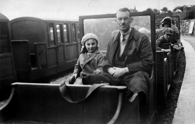 My mother and grandfather on the small-gauge railway up to Mount Snowdon, in Wales, c. 1931. Scanned from a negative.  The mustache worn by my grandfather was a common one even during WWII. It wasn't until after the war that people seem to have seen this as a "Hitler Mustache" instead of a common mustache that Hitler happened to favor. Grandfather still had the same mustache up until he died between VE Day and VJ Day. I haven't yet been able to identify the railway that this train belonged to. The one still in the business says it isn't theirs. View full size.
