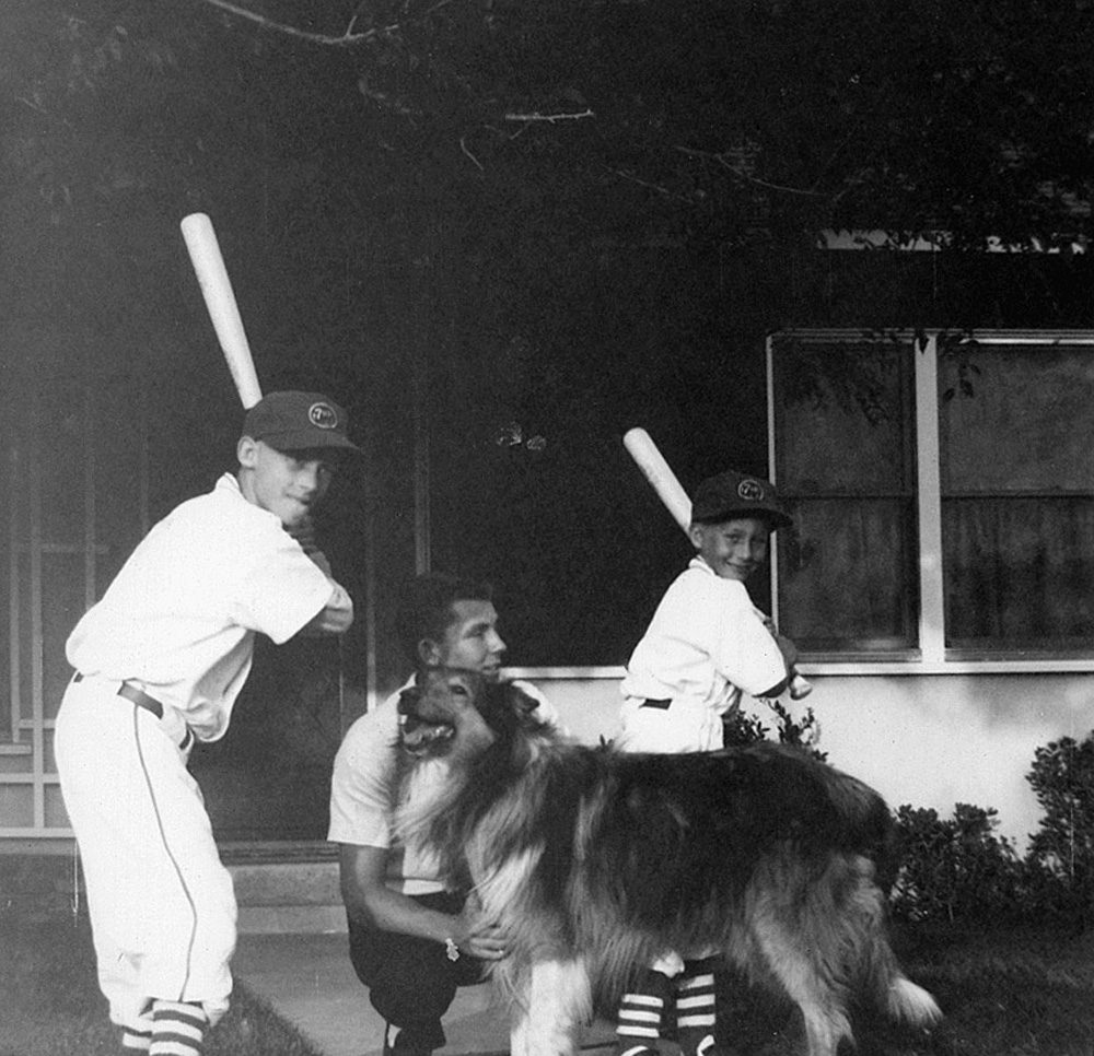 Herb and Paul with our uniforms and bats ready for action before heading out to our little league game. Our faithful dog Woo Woo and our friend Eric in the middle. Front yard with elm tree limbs above. View full size.