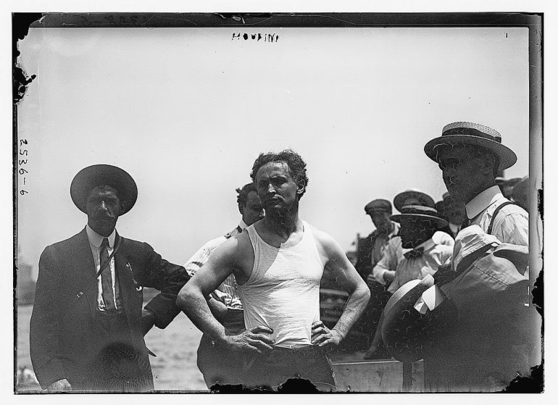 Harry Houdini on New York's East River, July 7, 1912. One of his most famous publicity stunts was to escape from a nailed and roped packing crate after it had been lowered into water. View full size.
