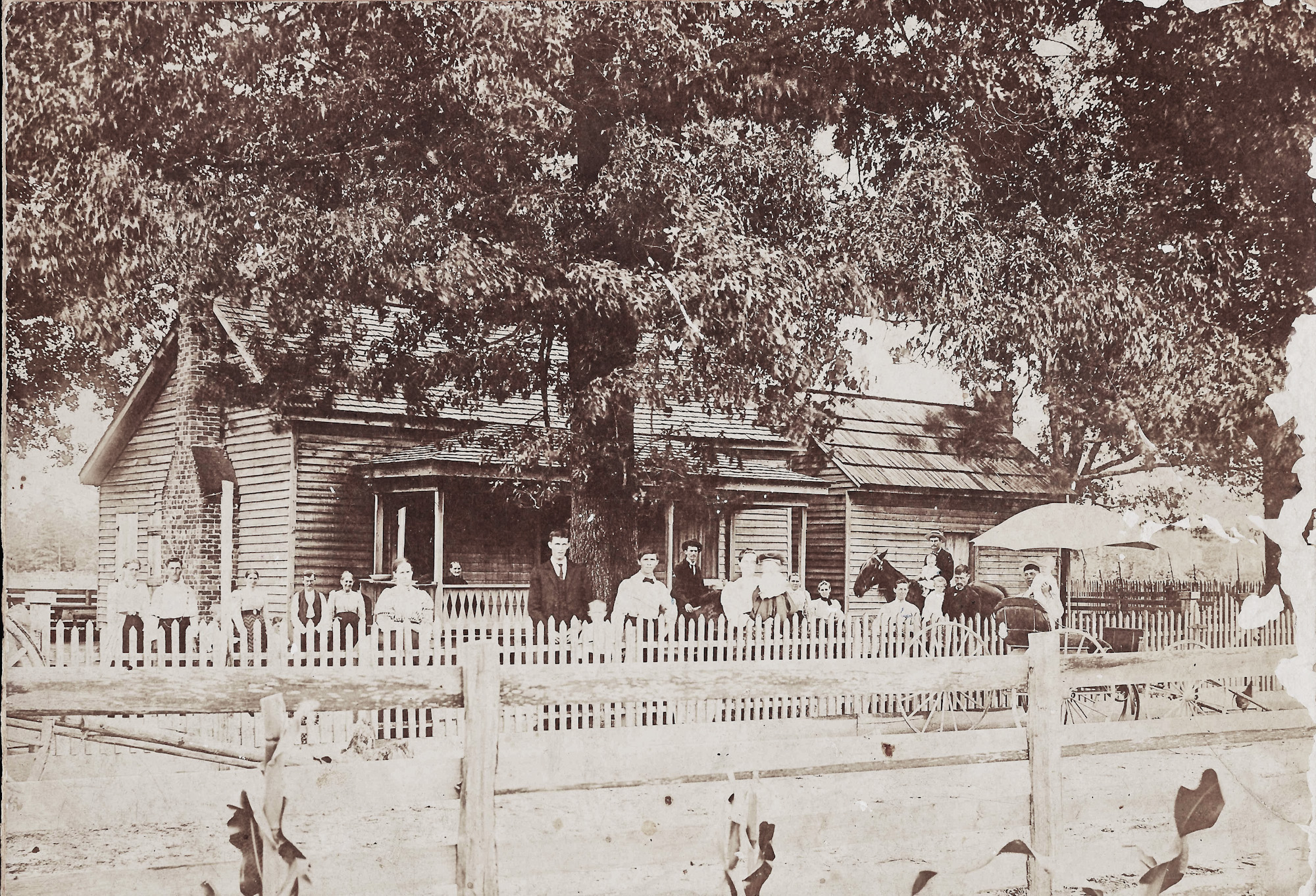 This is a picture of my great-great-grandfather's home, believed to have been taken in the late 1800s. The man on horseback is believed to be my great-grandfather. Some of the people pictured are neighbors.  We had to have the house torn down in the 1970s after it was heavily damaged by lightning. View full size.