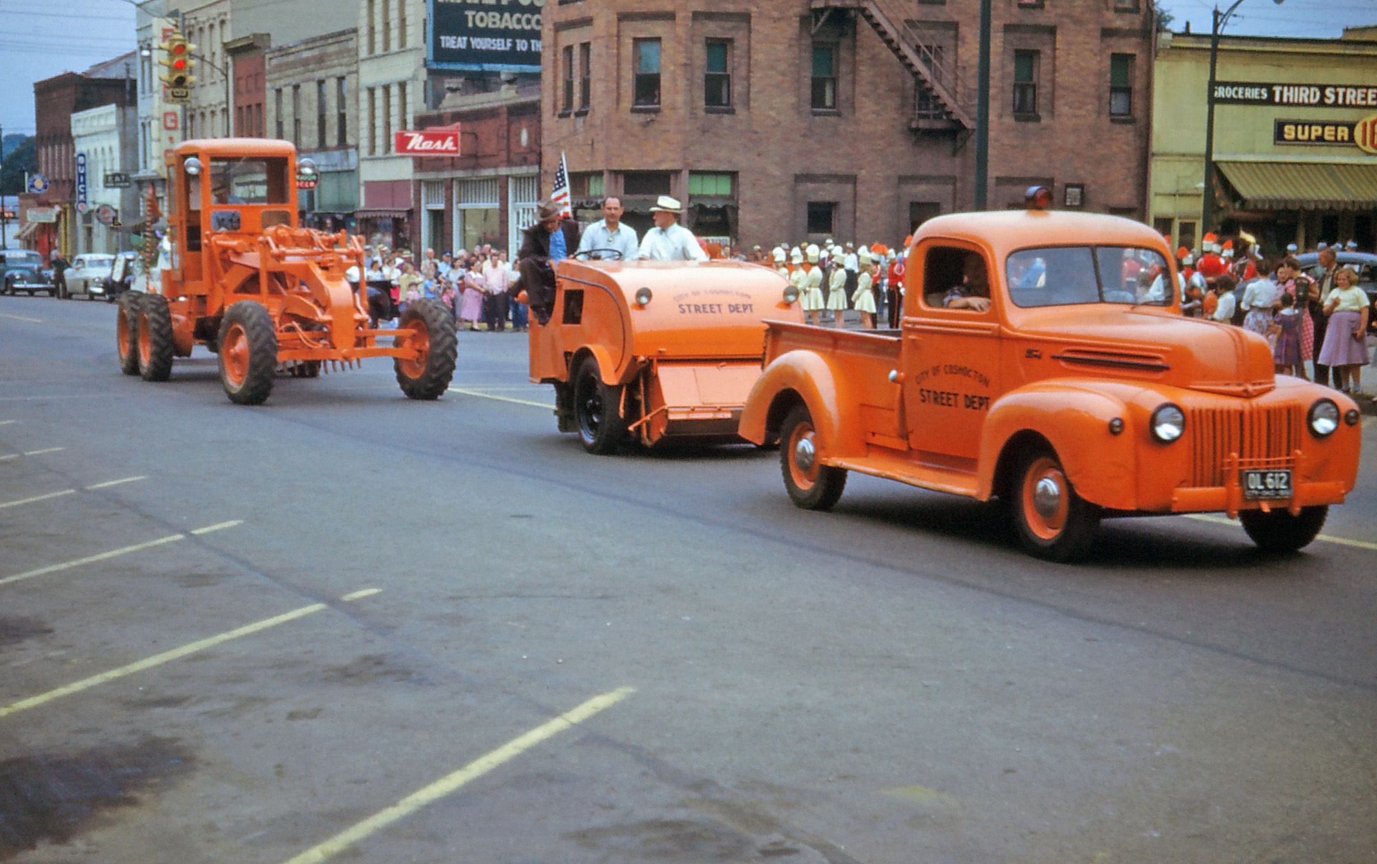A parade in Coshocton, Ohio, sometime in the 1950s, including the Coshocton Street Department decked out in safety orange.  From my grandfather's Kodachrome slides. View full size.