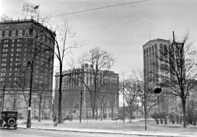 Due to my Grandfather's work with Pierce Arrow, I took a stab at guessing the location. Using Google maps and some online history of the Statler Hotel I was able to match the image to Detroit's Grand Circus Park.  The next guess is the date. Possibly about 1915-20. View full size.