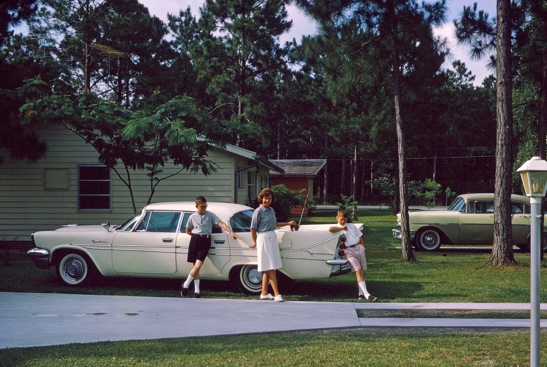 This photo, showing our 1958 DeSoto Firesweep (thanks, ptcruiser, for the ID!), was taken in Apalachicola, Florida, in 1964. I'm at the left, pointing seemingly at nothing, along with my mom, my brother Jeffrey and our new Chihuahua, Tiger. My dad, as a pilot, was always on the lookout for a great place to keep his airplanes, and Apalach had an abandoned Army Air Force training field with big empty hangars to spare. View full size.