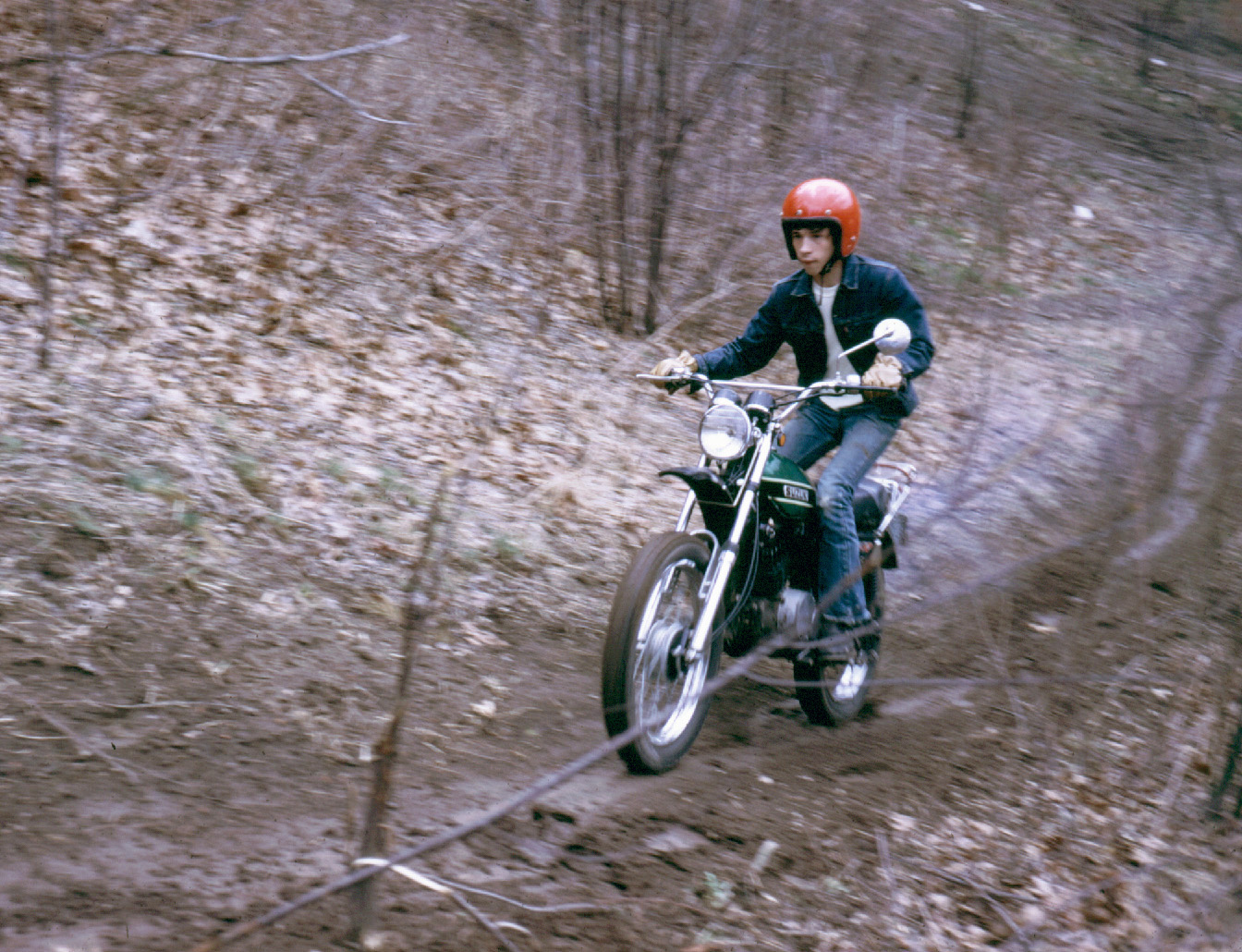 Charging a muddy hill behind Derby Downs in Akron, Ohio in 1974. It's my new 71 Suzuki 185. View full size.