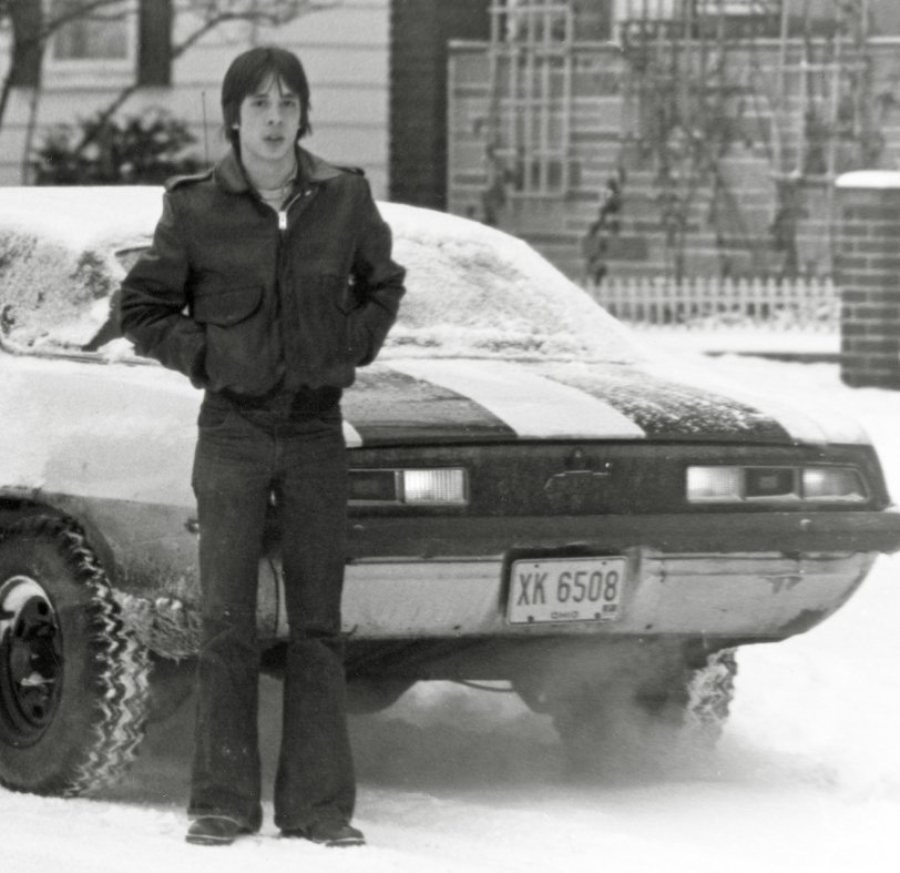This was winter 1976, Akron, Ohio, and I was heading to school.  My friend Shane took the pic; we were both taking photography class at school using black and white so we could develop it ourselves. I still have that bomber jacket! View full size.
