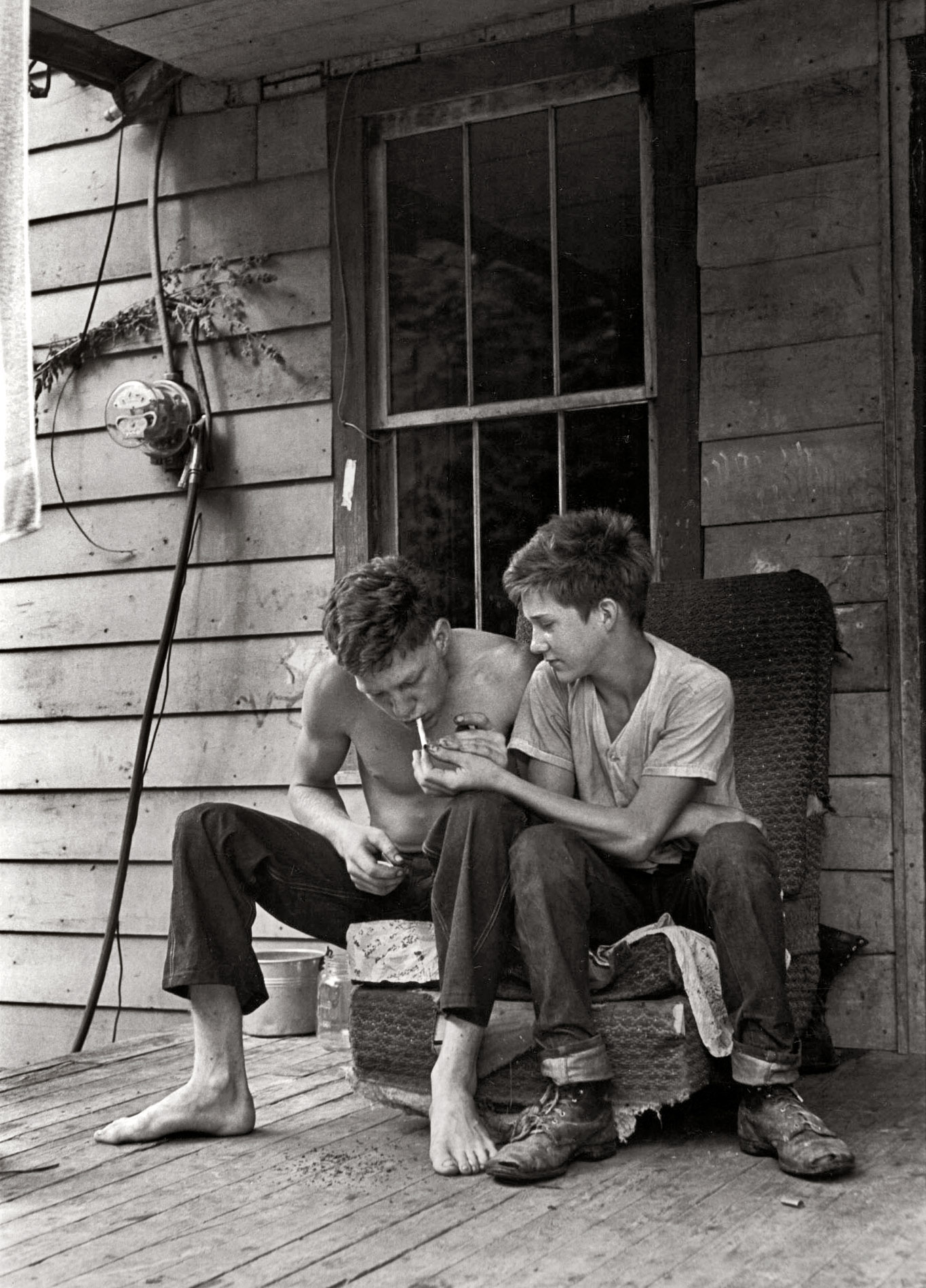 Leatherwood, Kentucky, 1964. "Cornett boys sitting on porch lighting cigarette." From a series of photos made in 1964 and 1972 by William Gedney documenting the lives of Willie and Vivian Cornett, their 12 children and grandchildren. Gedney Photographs Collection, Duke University.  View full size.