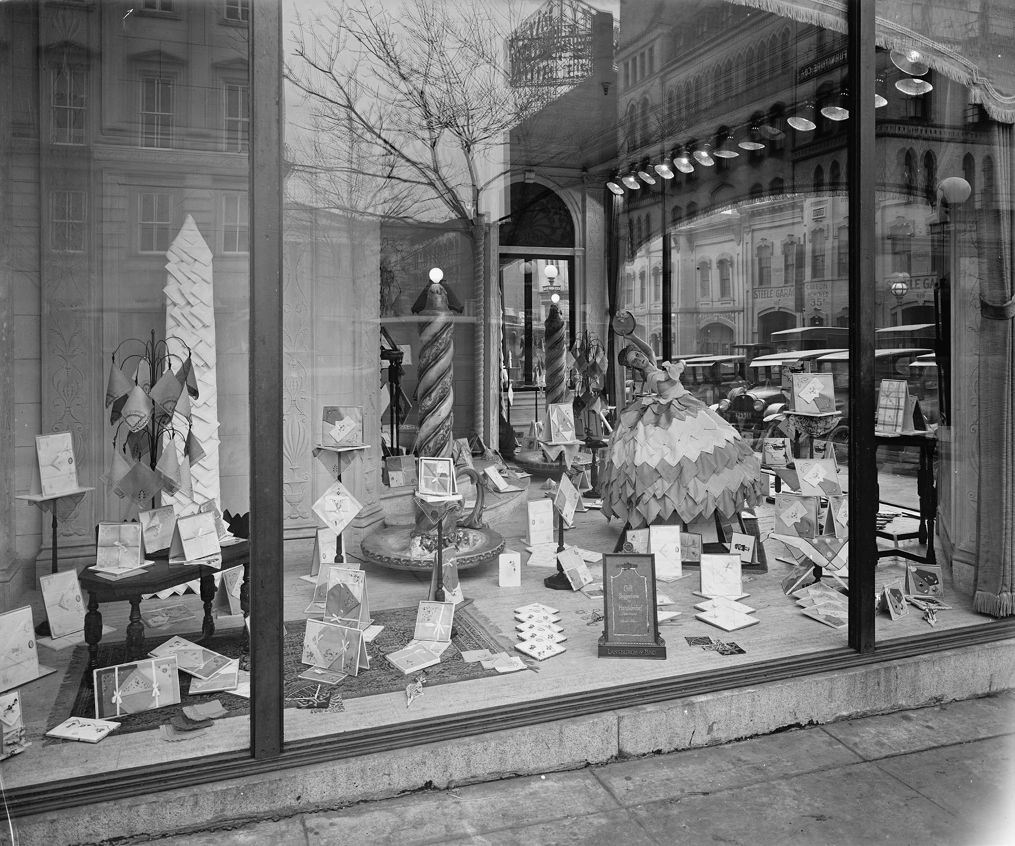 Window display of handkerchiefs at Lansburgh & Brothers Department Store. The building, now a CVS Pharmacy still stands at the intersection of E St NW & 8th St NW, Washington D.C. Most of the buildings reflected in the glass and across the street have also survived the passage of time. View full size.