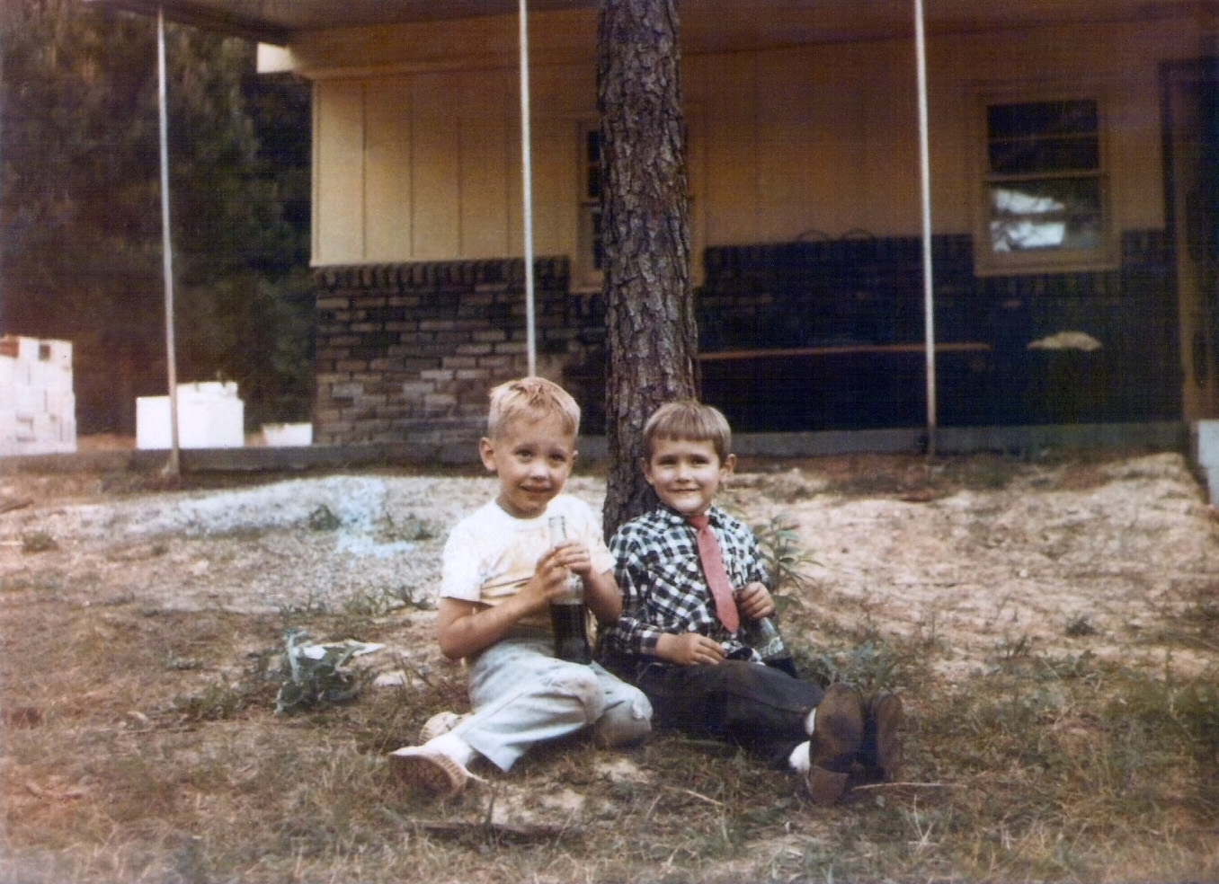 This is a photo of my cousin Troy, the kid wearing the red tie, and myself, the one in the dirty tee shirt on the left. It was taken in 1968 and depicts our great relief after being found by our parents after hours wandering in the Alabama backwoods behind Troy's house - the one in the photo. Troy wore ties at that time because he thought it made him look like Elvis Presley. Troy and I wandered onto a  neighbor's property who took us in and called our parents. View full size.