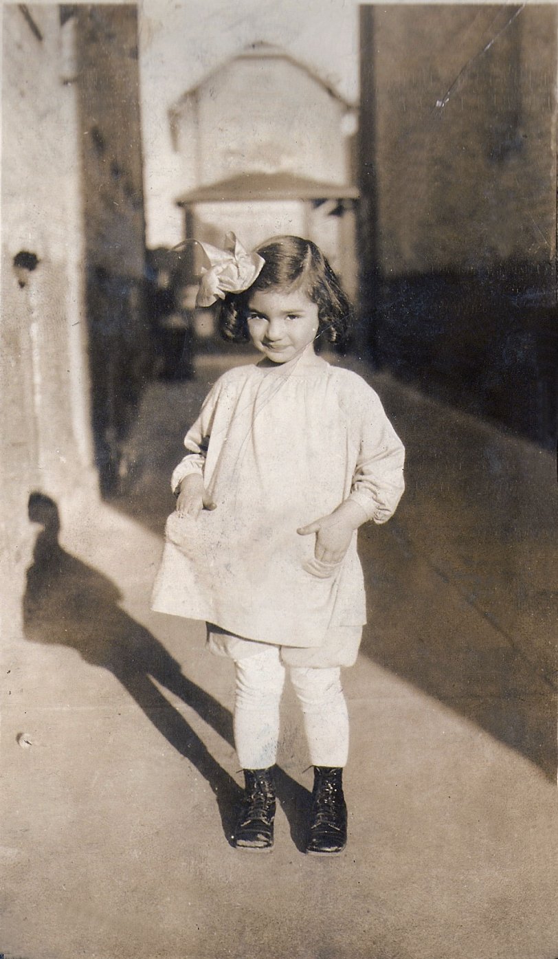 This photograph of my mother was taken in 1928 in Brooklyn, New York in an alley off of East 3rd Street. View full size. 
