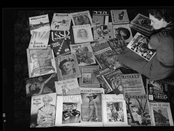 Found negative in a dumpster in Portland, Oregon. Unknown photographer. View full size.
The world at your fingertipsA nice selection of magazines, mostly European. If someone recognizes a specific cover we may get a year for this photo; I'll guess c. 1936 - 1939. May dates from around December from the 2 Christmas issues seen.
Hitler on the front pageThe Christmas magazine says 1936 on it.
I wonder what this woman is doing with such a diverse number of magazines?
The German magazine 3rd from the top row.
Arbeiter-Illustrierte-Zeitung or AIZ (in English, The Workers Pictorial Newspaper) was a weekly German illustrated magazine published between 1924 and 1938 in Berlin and later in Prague. Anti-Fascist and pro-Communist in stance, it was published by Willi Münzenberg and is best remembered for the brilliantly propagandistic photomontages of John Heartfield.
In 1930 began the magazine's association with John Heartfield, whose photomontages savagely attacking both National Socialism and Weimar capitalism became a regular feature. In the years leading up to 1933 the circulation of AIZ reached over one half million. After the seizure of power by Hitler the AIZ went into exile in Prague, continuing until 1938 under editor-in-chief Franz Carl Weiskopf.
BIZ, not AIZThe German magazine is in fact the Berliner Illustrirte Zeitung (BIZ, Pictorial Newspaper of Berlin), rather than the AIZ.  Founded in 1891, it was Germany's first mass-distribution newspaper and had a circulation of almost 2 million by 1933/4 by the time Hitler and the National Socialists came to power.
The popular newspaper was taken away from its Jewish owners by the National Socialists during their time in power and used as a propaganda sheet, which probably explains the relatively sycophantic photograph we see on the cover here.
During the NS Party's stewardship of the BIZ, they changed its name from the traditional spelling of "Illustrirte" to the contemporary "Illustrierte", presumably at some point after the edition we can see in the photo.
The original owners regained and sold the business once war and National Socialism ended in 1945.
Amazing set of magazinespresented here:
Algeria, Nynorsk (New Norwegian) Vikeblad, Berliner Illustrierte Zeitung, a Hebrew(?) magazine, La Revue de Madagascar, Cameroun, La Turquie Kemaliste, USSR in construction, Illustraçião, Cadelp, ....lly Times and Witness Christmas Annual, Valis-Eesti No.1 Almanak 1935, The Passing Show 1932 UK, Kaunas (Lithuania), Morze (Polish: The sea) Numer 6 (128) z 1935, The Trinidadian, Tidens Kvinder (Danish: future women), Dublin Opinion, The Outspan (South African), Jadranska straža (Croatian: Adriatic watcher), Sumatra, Tolnai Világ-lapja (Hungarian: World Journal of Tolnai), Minerva (Albanian), Ceylon Causerie illustrated, a Japanes(?) magazine, Vie à la Campagne (Hachette), Revista la Semana (Brazilian), Domus (Italian?), ..pestry Tyden, L'Asie Nouvelle illustrée (Indo-Chinese, Saigon), Theatis (Greek),
Boabe de Grâu (Romanian: Wheat berries)
(ShorpyBlog, Member Gallery)