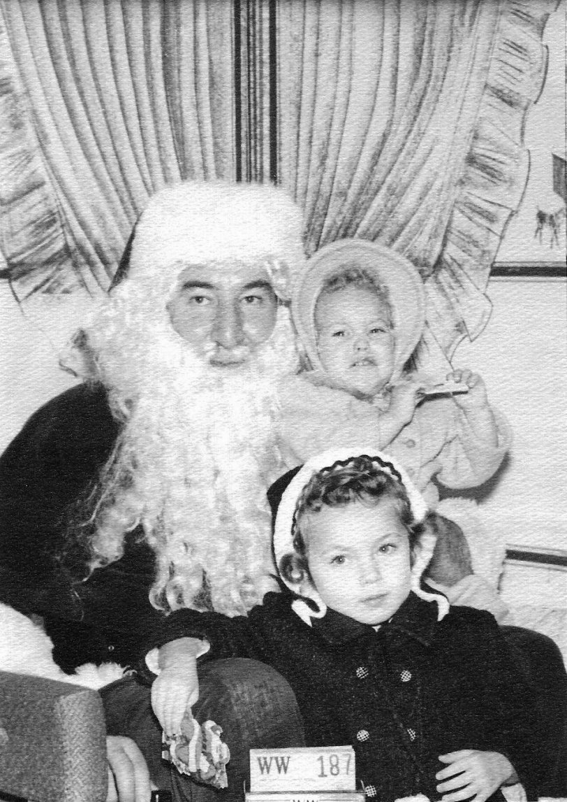 I was four and my sister was 21 months here. This was taken in Walla Walla Washington, where we lived for the 15 months Dad was stationed on Okinawa. Not the kindliest Santa I have ever seen. View full size.
