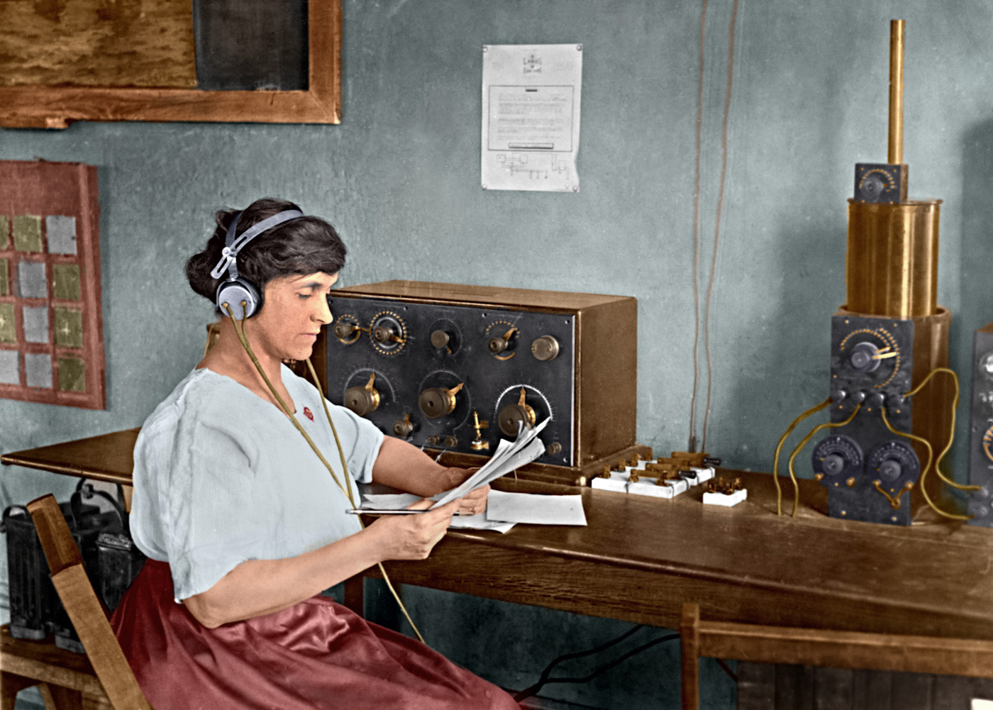This colorized image shows Mary Texanna Loomis, the first woman in the U.S. to run a radio school, operating her radio station in 1921. Her school, the Loomis Radio College, operated in Washington, D.C., in the 1920's and 1930's.  She is seated at an early receiver that uses a panel mounted crystal detector.  The knife switches to the right are probably antenna selectors.  Next to that is an antenna tuner called a "loose coupler", which is connected to a tube receiver out of view on the right.  

I optimized the image in Photoshop and colorized it using AKVIS Coloriage software.  The original black and white photo is in the Library of Congress collection and can be seen at http://www.loc.gov/pictures/item/97504677/. View full size.