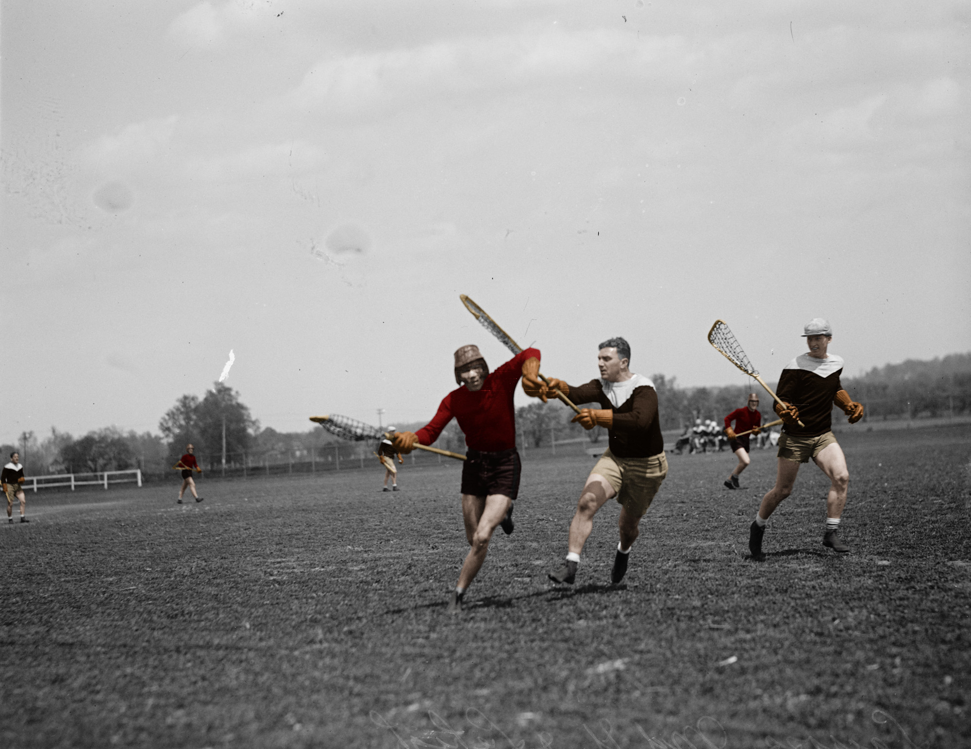 A colorized version of a picture of a lacrosse match between Maryland and Lehigh in 1925.

I could not find any information as to which team wore which uniforms or what the colors were back then so I took the modern colors for each school and assigned them as I saw fit.

Maryland currently has Red, White, Gold, and Black so I assigned those colors to the team with the dark jerseys.  There is also a picture of a Maryland player from 1924 whose uniform closely matches this set.

Lehigh has Brown and White which I assigned to the team with the white shouldered jerseys. View full size.