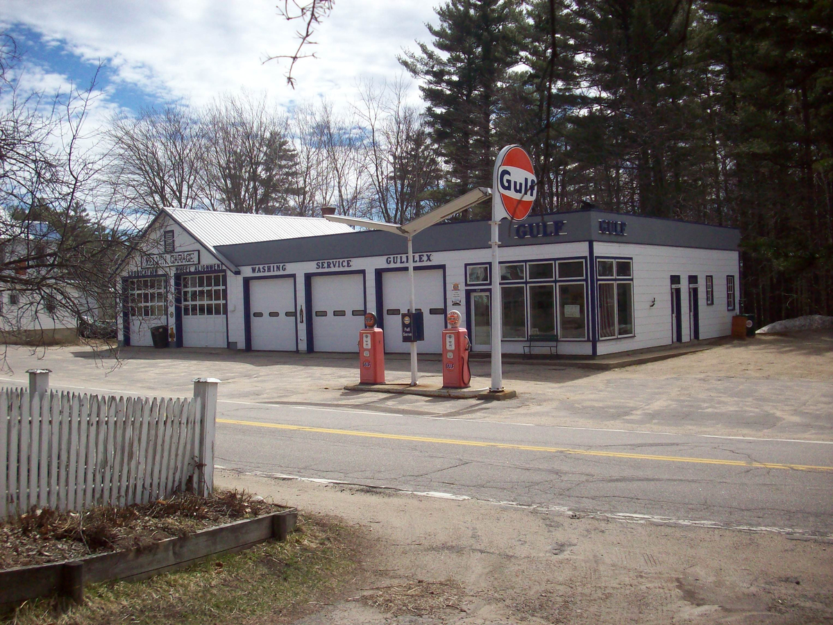 April 5, 2009. The Gulf station in Melvin Village, New Hampshire. Note that the flat-roofed section, although one bay longer, is identical in design to the one in this photo contributed by Don in Va. I'd say that these two buildings have a Gulf Oil architect in common. This garage is the property of John Warner, who is also the proprietor of the Hooterville Airport in Kenney, Illinois. View full size.
