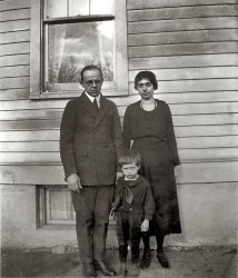 Since the Brittons, Carpenters, and Tylers have already made their appearances in the Shorpy Blog, I thought I'd better post something from my father's side of the family. So here's Dad, about age 3 in 1922, with his parents, Steve and Elsie (Peiser) Miller. They all look pretty dubious of the photographer's abilities, don't they?

Steve Miller
Someplace near the crossroads of America