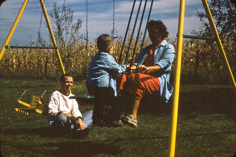 My mother and I on the teeter-totter, with dad watching. My grandfather probably took the shot on an Argus camera loaded with Kodachrome. This slide was taken in the fall of 1955, near Blandinsville, Illinois. View full size.
