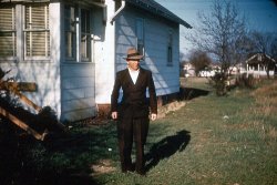 This is a photo of my Grandfather, Joseph Ditzig, taken in 1948, in front of his "kit house" built in 1926. I understood that this house was built from a kit, sold by Sears and Wards at that time. Grandfather and his brother, Uncle Hank, dug the basement after the house was built. I would have liked to have seen how they did that! The house was purchased for $1200 and sold in 1965 for $20K.
I remember a coal bin in the basement that fed a monster of a furnace, ugly with big black arms going all over! What a thing to scare a kid! But I also remember the smell of fried chicken that finally overcame the pervasive smoke of his Herbert Taryton cigarettes.
Lost Grandfather in 1961. (Thanks American Tobacco Co.) View full size.
Kit housesMy dad's grandparents built a kit house in Enterprise, Kansas, in the 1920s.  Bungalow style.  It's still there but I didn't get a good look at it several years ago when we drove through town.  I told my kids that people could once order a complete home from a catalog and it boggled their minds.
Sears Kit HousesThere are still a few of these "kit" house on the Jersey Shore. I have a co-worker who recently bought a "kit" home that was put together in the 40s.
Sears catalog kit housesYou can still buy kit houses.  They're especially popular in contemporary log cabin styles.  
The ones Sears sold have held up very well.  There are two of them near me (northwestern lower Michigan, near Torch Lake), and both are snug and sound more than 70 years later.  Nicely finished, too--nothing fancy, but everything of good quality.  
(ShorpyBlog, Member Gallery)
