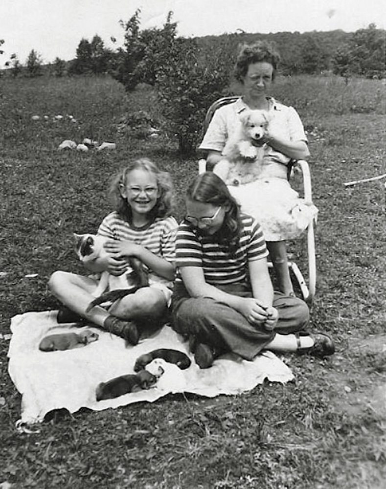 Our dear darling Myrtle, who was our live-in babysitter as long as I can remember, holds puppy Tobie. Me holding the cat and my sister. Our very first dog Daisy who was expecting when my dad brought her home after she was abandoned. Daisy died giving birth and the neighbor next door had the cat which had recently had kittens. That cat nursed those puppies and saved them. We kept one, named her Daisy 2, and gave the others away.  The cat and puppies made news and was pictured in the Binghamton Press. 

