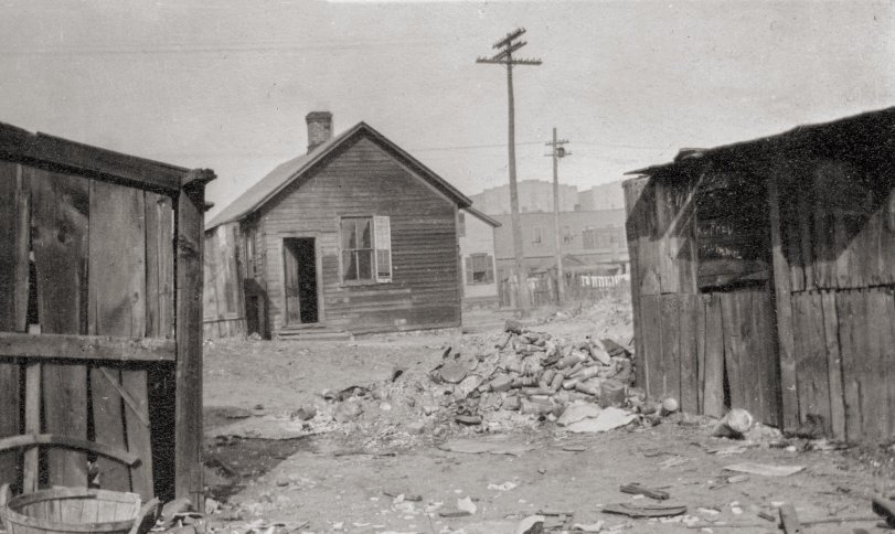 The slums at Cinder Point between the Railroad and Illinois River, at the foot of Sanger Street, nearby the Flatboat City locale, Peoria, Illinois, circa mid-1930s. The Hiram Walker &amp; Sons Distillery plant can be seen in the background. Picture taken by an unknown employee of the Neighborhood House social service agency, which delivered meals to kids and the elderly. 
Neighborhood House Association, 1020 S. Matthew, Peoria IL, established in 1896, is dedicated to providing a Safe Haven with comprehensive services that meet the social, emotional and material needs of individuals and families from infancy to the elderly.
