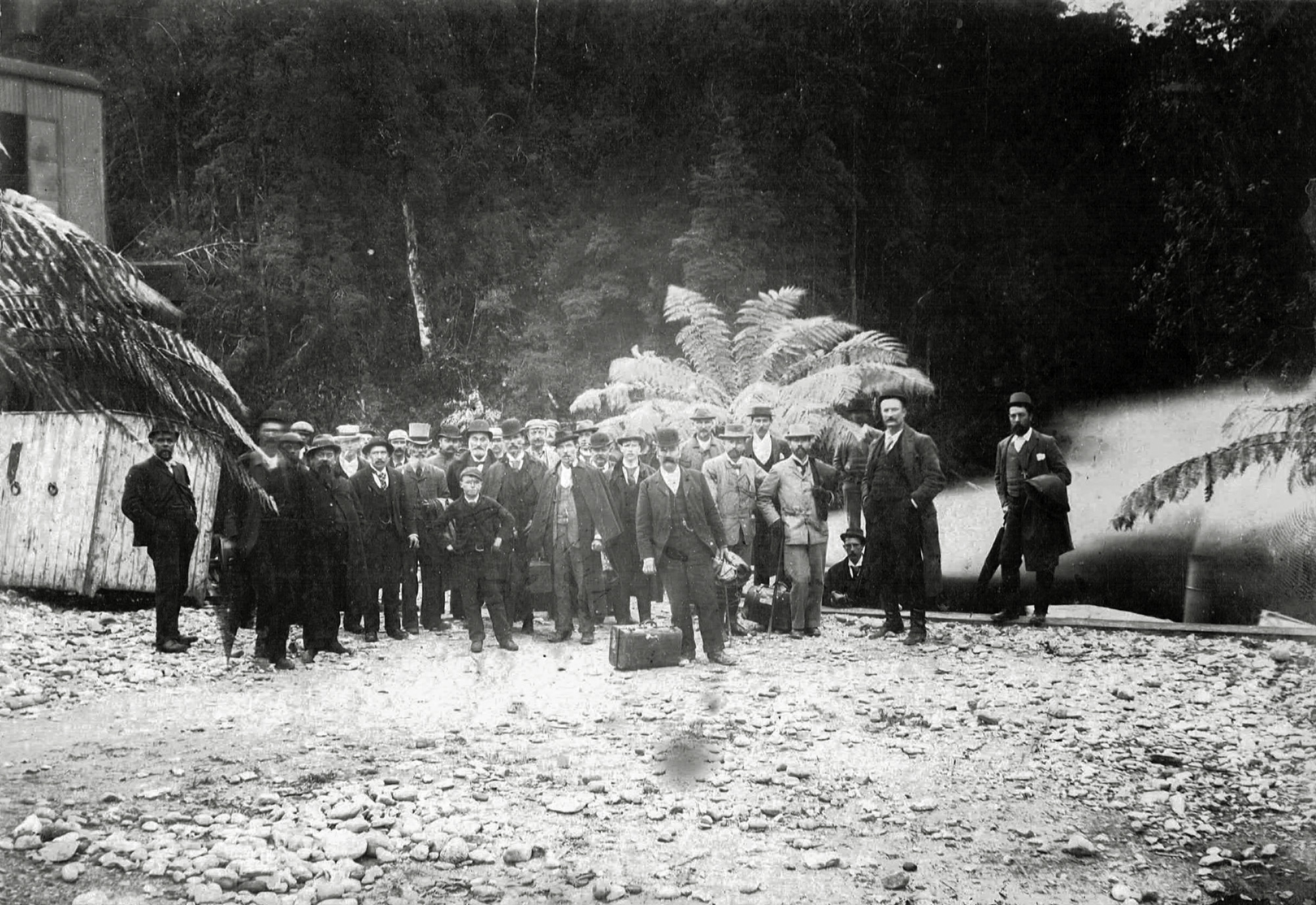 Frederick O. Henry, the short and bearded Scotsman standing fourth from left, made a fortune in the early mining days of the Tasmanian West Coast. My children are his great-great-grandchildren. Behind is the steam from a boat that linked the river port of Teepookana to the sea port of Strahan. Strahan flourishes today as a tourist destination. Teepookana is overgrown by the forest. This professional photograph by J. Mills of Zeehan comes from the F. O. Henry family archive. View full size.