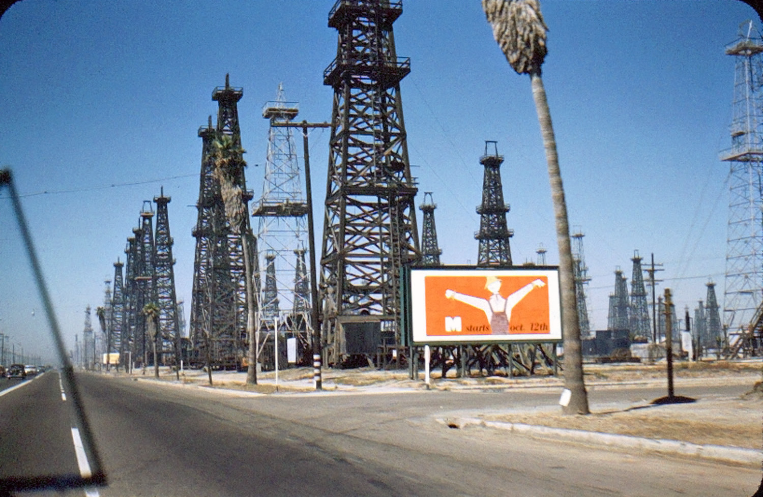 I see palm trees and the slide was found here in California so I'm guessing this is in California in the 1950s. Oh, and "M" starts October 12th, whatever "M" is. View full size.