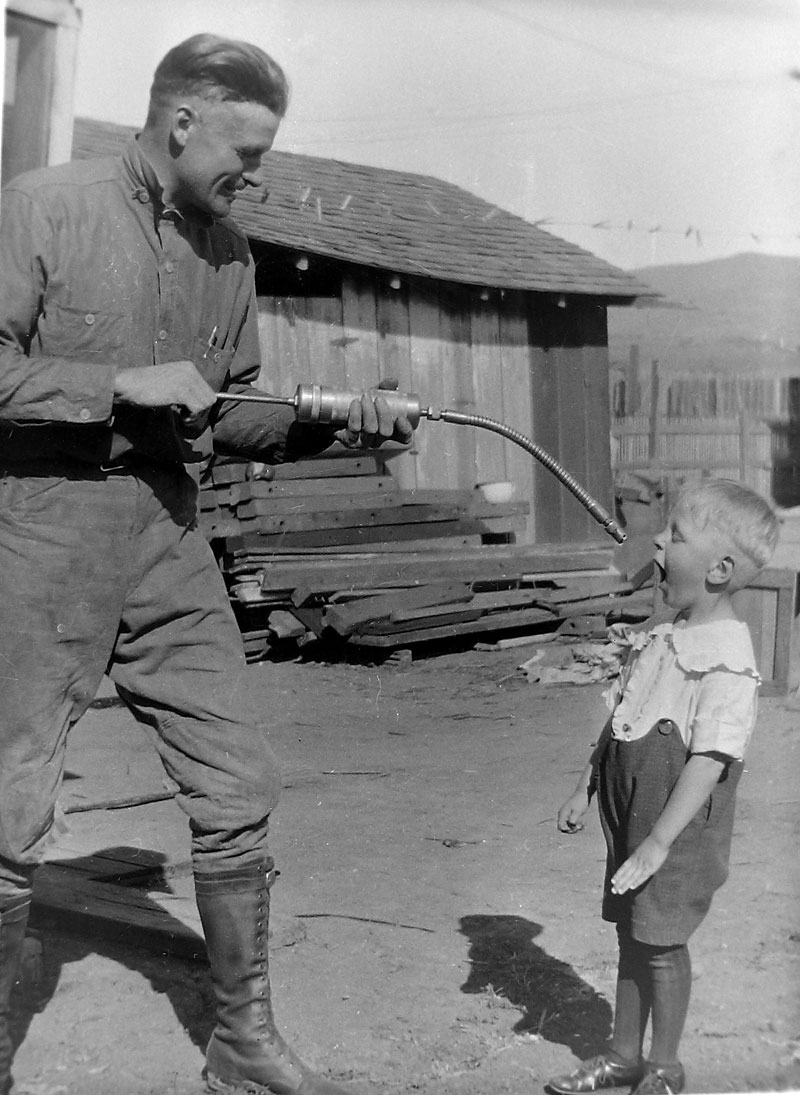 My grandfather's sense of humor knew no bounds as he fakes squirting a nice glob of grease into my dad's mouth. Taken by my grandmother in about 1925, this is just one of many pictures she took at their new home in San Luis Obispo, CA. View full size. 