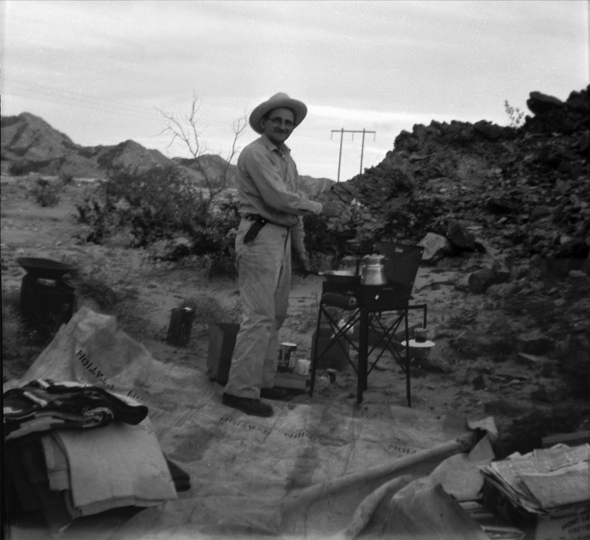 This is my great grandpa out camping. It looks like he's cooking up a steak on the Coleman stove. I don't know the location but I'd guess it's somewhere in the deserts of California. This was taken sometime in the '50s. View full size.

Scanned from a Kodak safety negative.