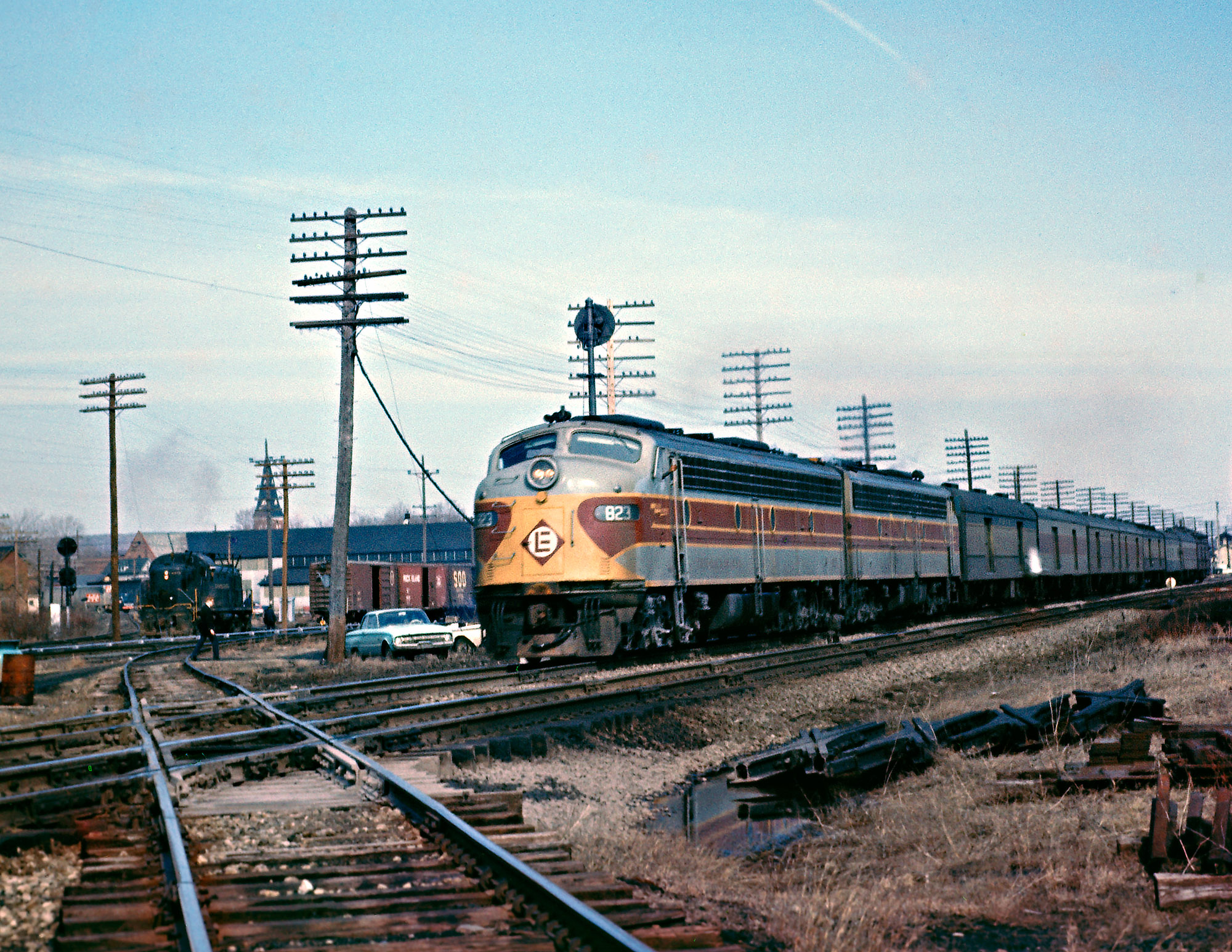 Erie Lackawanna's train 7, the Pacific Express, departs Corry, Pennsylvania westbound. It will arrive in Chicago in about 13 more hours, having stopped at every station on the route. An express it was not. Within a year the train will be discontinued, but Hoboken to Chicago service will continue with two other trains in each direction - Phoebe Snow and Lake Cities. Note the PRR Alco working in the distance. View full size.