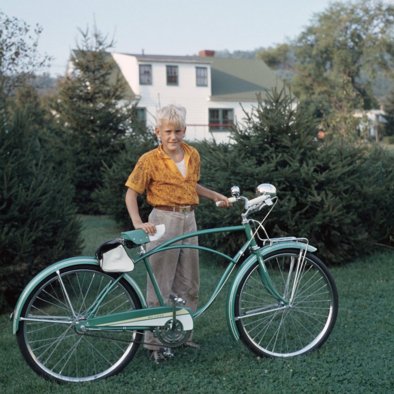 This is my husband Peter and his Rollfast Deluxe bike in about 1959 - I'm assuming he's about 10 in this photo.  It was taken in his backyard in Chenango Bridge, New York, outside of Binghamton.  His father was a chemist for Ansco, and this is taken from an Anscochrome slide. View full size.
