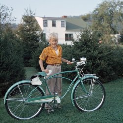 This is my husband Peter and his Rollfast Deluxe bike in about 1959 - I'm assuming he's about 10 in this photo.  It was taken in his backyard in Chenango Bridge, New York, outside of Binghamton.  His father was a chemist for Ansco, and this is taken from an Anscochrome slide. View full size.
Oh, that seatThe seat on that bike looks just like the one on my Dunelt in the early 1960s.  It was a piece of steel covered by the thinnest vinyl and man did it hurt.  I soon got a padded cover and added some kitchen sponges for good measure but the calluses didn't go away for months.
The Dunelt was a 3-speed bargain version of the Raleigh, also with Sturmey Archer gears.  I rode it for ten years or more and it passed through the family.
The flatness of Windsor made for lots of easy cycling at great speed. It was absolute heaven after the single speed monster my dad got me at Dominion Tire on Tecumseh Road.
Emergency stop not an optionLove the photo, and my first bike was very similar (albeit used)!  As anyone like me with a modern dual hydraulic disk brake equipped bike will attest, by comparison the function of this cable actuated rear-only internal drum brake is only to slightly slow the bike down.  You'd always need a Plan B with these monstrosities - either feet-to-pavement Fred Flintstone style, or just bail out.
Beautiful bike!And a wonderful image.  But I'd much prefer a good, reliable coaster brake!
GearshiftThat shift cable is for a Sturmey-Archer three-speed hub with coaster brake.
The hub came in two versions. The more common one had only the three-speed function with no coaster brake. Bikes with this version had hand brakes on both wheels. The much-less-common version had the three speeds and also a coaster brake! I had a secondhand Dunelt bike with this hub. This Rollfast apparently has this second type.
The S-A coaster brake was not nearly as effective as the single-speed New Departure coaster brake hub.
That Sturmey-Archer hubis a very complicated  gear system, worth a look at an exploded view internally.
Is it a Schwinn?I had a Schwinn very similar to this bike, the lever on the handlebar changed gears (it had two), is not a brake.  It had a coaster brake.
[Going by the caption, it's a Rollfast Deluxe. -tterrace]
Coaster Brakes 101There may be younger viewers of Shorpy that never rode a bicycle with coaster brakes. As mentioned by others, the brake is on the rear hub only, and was activated by reversing the pedals into a locked position which applied the brakes. You could apply pressure gradually, or do a panic stop that often locked up the rear wheel into a skid. This was especially fun on gravel roads or grass. This shortened the life of the rear tire considerably. While Windsor is very flat, we later lived in a hilly city, and coaster brakes had limited effect on steep hills.
Here is a photo of me with my sister taken in Riverside, (now Windsor) Ontario in 1958 when I was ten years old. While my earlier bikes were second hand, my parents finally gave me a new CCM (Canada Cycle &amp; Motor Co.) single speed bicycle with coaster brakes. It had a headlight, carrier and an electric horn. By comparison, my present bike has 21 speeds. 
3 on the TreeAs noted already this bike had a multi speed rear hub. My first bike, (a 1966 Sears version of a Sting Ray) had the same setup, the brake worked fine, the transmission not so much.  
The first time it falls over or scrapes a curb, the elbow for the cable gets broken off, leaving you stuck in high gear, i.e. stranded.
Sturmy-Archer transmissionI had a S-A transmission in my first new bike, about 1969.  It wasn't very good and the local bike shop sold me a Shimano replacement.  I still have it and it works fine.  By the way, when everyone else was riding stingrays I was the first in town to have a big bike with skinny tires.  I had a light powered by an generator that rubbed the tire and a speedometer.  Had it up to 50 mph down a big hill.  Really thought I was doing something!
Too complicatedI had a bike (Schwinn? don't remember) with the S-A 3-speed hub with coaster brake (plus a front caliper brake).  I had a lot of trouble with it - I kept stripping some internal part or other, and it spent a lot of time in the shop.  I came to the conclusion that the two functions (brake and transmission) was one too many.
Three speeds?  Luxury!I grew up the late '60s and early '70s riding single-speed hi-rise bikes from Penney's.  The first, a birthday present when I turned nine, was stolen after two years from the bike rack at school; I still miss that beautiful magenta bike.  A year later I found a $20 bill while walking home from school, and that helped pay for my next ride, an orange Penney's Scrambler I, which cost $34.95.  Of course both bikes had modifications and tire replacements courtesy of parts and tools from the nearby Western Auto store.
I did know a couple of kids that owned two-speed coaster brake bikes (very unusual, and I assume made by Sturmey-Archer), and I got to ride them a few times.  Changing gears up or down was accomplished by reversing the pedals just enough to change speeds without braking.  I always wanted one of those, since the design was simple, you got more than one speed without having to worry about maintaining or replacing derailleurs, cables, levers and brake shoes.
Same colorsAs my J.C.Higgins bike I bought from Sears with my own money backing 1954 as a 12 year old. In fact, my Dad's new '54 Chevrolet Bel-Air was also that green &amp; cream combo. 
Kick-shiftI worked in a bike shop in the late '60s. The two speed coaster brakes referenced by Born40YearsTooLate were made by Bendix. We called 'em kick shifts. They were popular with paperboys at the time, who had them installed in heavy duty Schwinn models with springer forks.
(ShorpyBlog, Member Gallery)