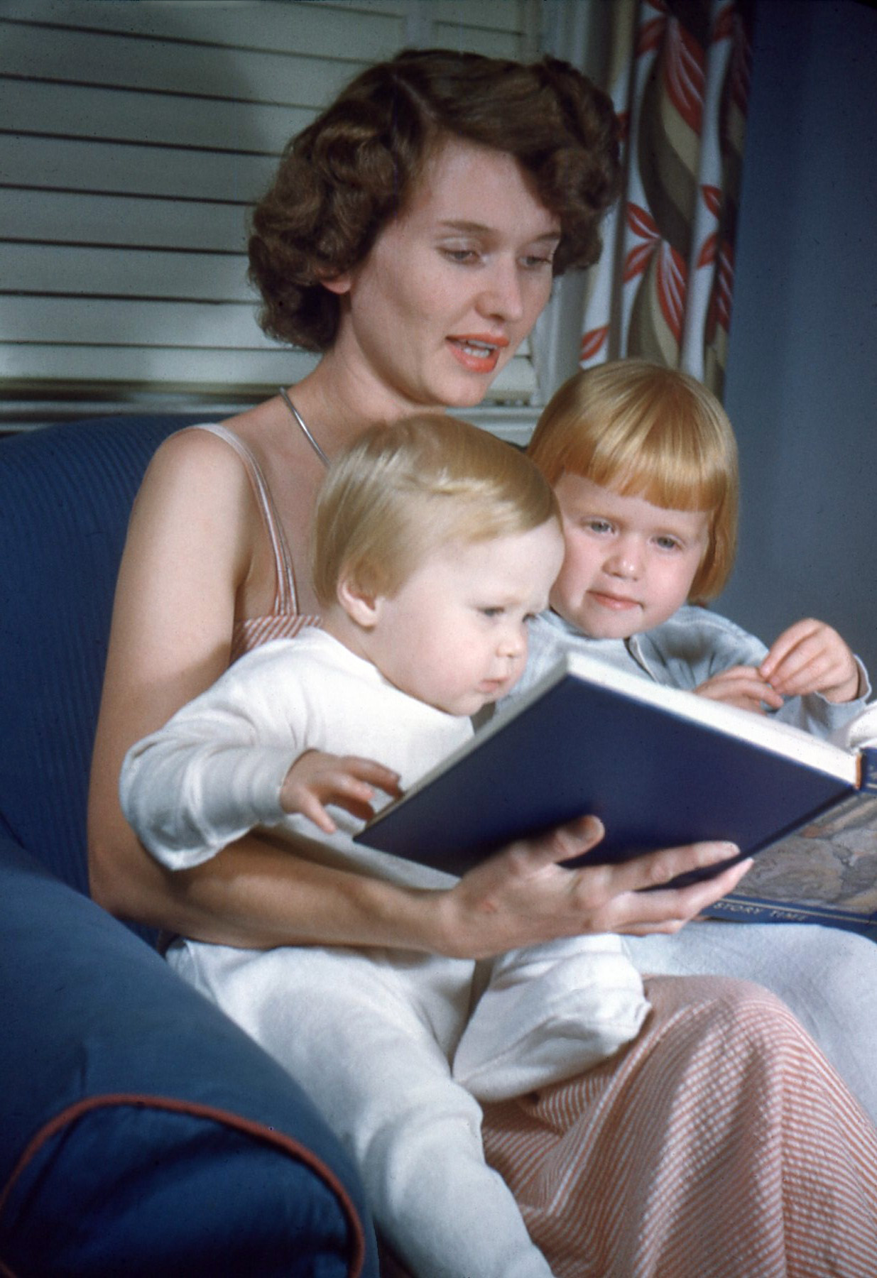 From my dad's old Kodachromes comes this one of my mom, Dorothy Porter, in 1949, reading a bedtime story to my two sisters, June and Madge, at our home in Greenville, S.C..  She is reading from a collection of children's stories that were contained in twelve volumes, called "My Book House".  These sets were sold by door to door salesmen in the 30's, 40's and 50's.  I loved it when Mom read to me from this set of beautifully written and lavishly illustrated stories, but alas, they fell victim to our evolving culture.  Some of the entertaining stories they contained, such as "Little Black Sambo", and Uncle Remus (Joel Chandler Harris) tales came to be regarded as politically insensitive and so were deleted from the American lexicon of acceptable children's literature. View full size.