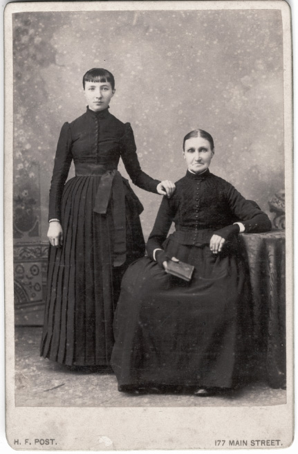 In the eighties a distant cousin discovered the photo album of his grandparents, Geurt Stoffels (1865-1956) and Johanna Gerhardina van Tongeren (1868-1947), after the album had been locked up in a room for more than 30 years. Geurt Stoffels was a miller in Witmarsum, Friesland, Netherlands, and made the album about 1896.
One of the pictures in the album is this one, probably taken about 1895, probably showing a stepsister of my greatgrandfather Evert Jan Stoffels. The picture is made in Paterson, NJ. The woman at the right must be Pieternella Geertruida Veldhoen "Nelly" (1824 Elburg, Gelderland, Netherlands-1899 Paterson, NJ). The younger woman will be a daughter or granddaughter. Nelly was married to Ayrus/Azweerus Hagedoorn, with whom she arrived in the USA in 1873. The black clothes probably refer to a strict puritan protestantism. View full size.