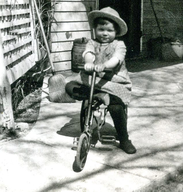Toddler poses to have a picture taken with his very neat tricycle. Year is approximately 1919. Back of photo says his name is Richey, though whether that is his first or last name is unknown because the picture is cut in half and there is a word above Richey one can only see an edge of. From a photo album I purchased at an ephemera swap meet.