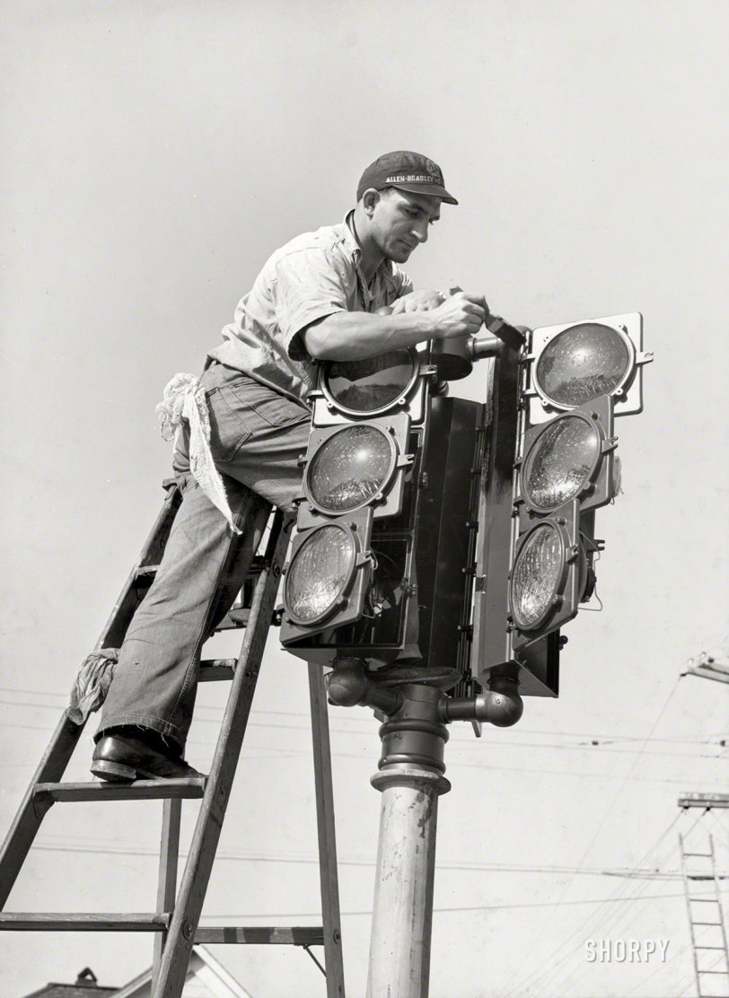 December 1940. "Putting up a new traffic signal in San Diego." Photo by Russell Lee for the Farm Security Administration. View full size.