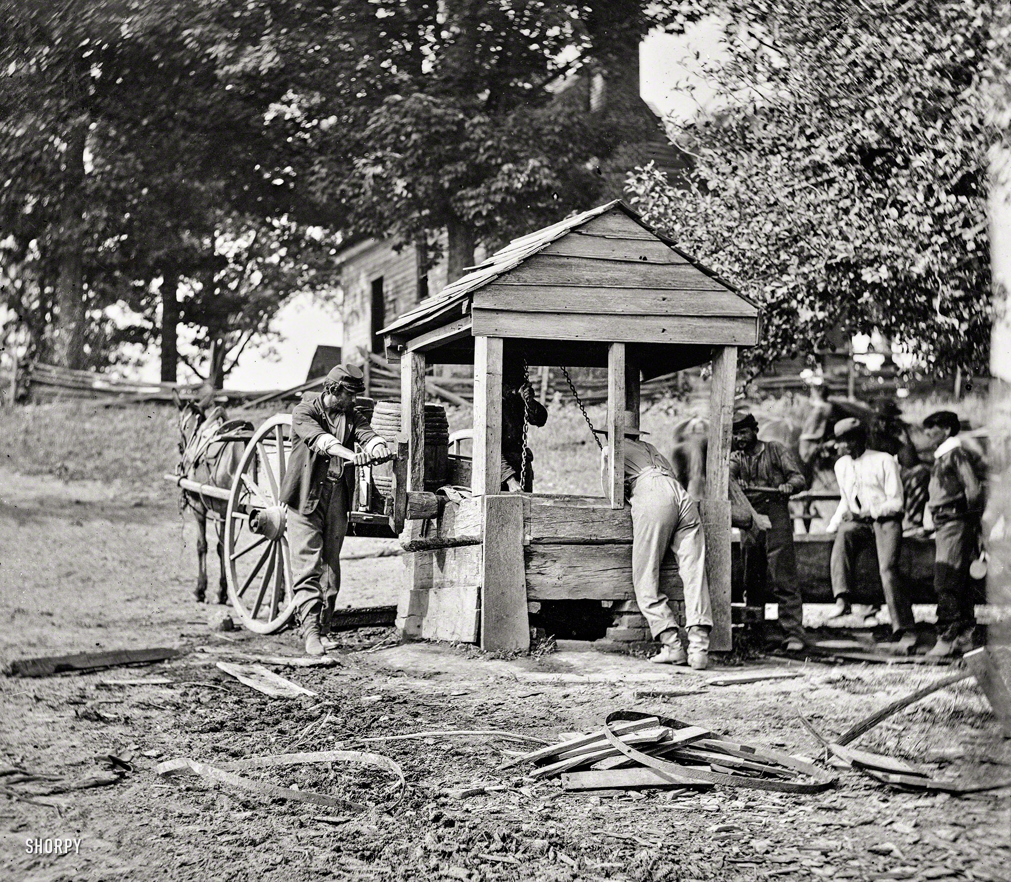 1864. Fredericksburg, Virginia. "Army of the Potomac soldiers drawing from a well, filling their water cart." Wet plate glass negative. View full size.