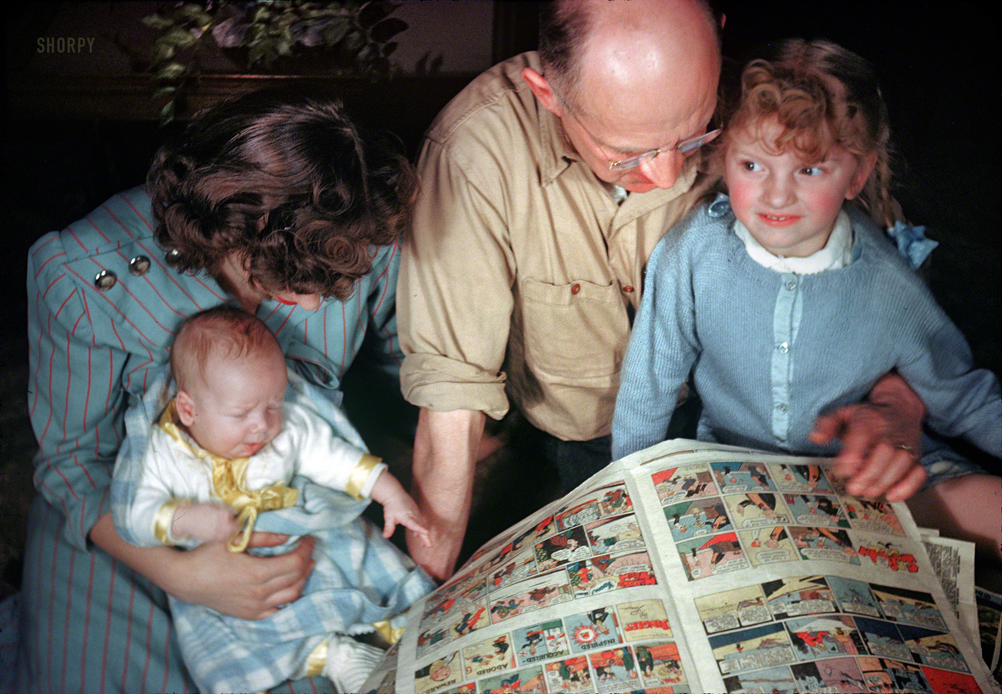 Our Michigan mom (last seen here) is back with the kids and Grandpa, paging through the Sunday comics. 35mm Kodachrome slide dated 1947. View full size.